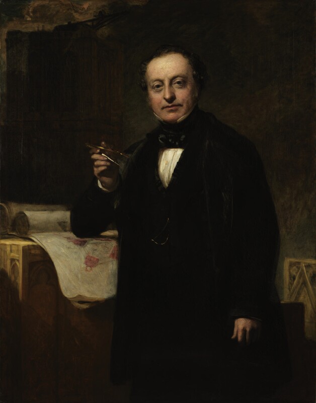 Painted Portrait of Sir Charles Barry. In a dark room, with a high table topped with rolled up parchment of seemingly architectural drawings, he is standing, elbow on the table, with a writing compass in his right hand. He is wearing a dark black suit with an overcoat, black thick necktie and a white shirt with a high collar. He is clean shaven with short dark hair.