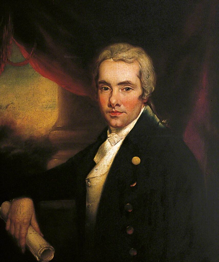 A half-length portrait of William Wilberforce senior. In front of a background with a dark red curtain across, the bottom of an ornate pillar and a sunset sky, he is wearing a dark suit coat with large golden buttons, a white waistcoat and a white frilled high collar shirt. In his right hand he is holding a rolled piece of parchement. He is clean shaving and has long grey hair tied behind his head. 